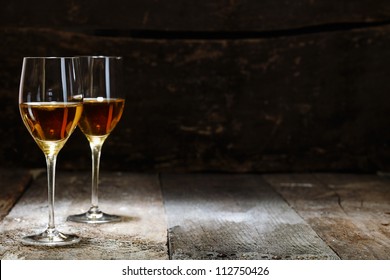 Two glasses of sherry on brown wooden background with copyspace - Powered by Shutterstock