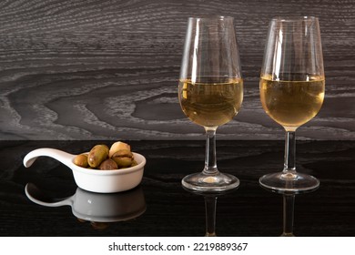 Two Glasses Of Sherry Wine And Seasoned Olives