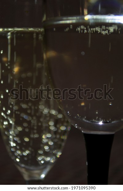 Two glasses of sparkling champagne with\
bubbles on a neutral\
background