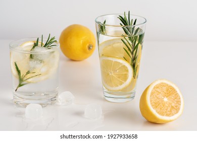 Two Glasses Of Water With Lemon Slices, Rosemary And Ice.