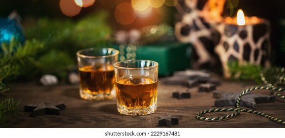 Two glasses of whiskey or bourbon with Christmas decoration on dark background. New Year, Christmas and winter holidays whiskey mood concept - Powered by Shutterstock