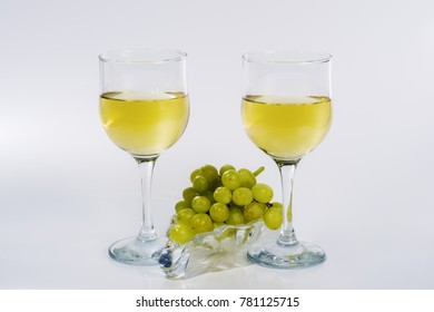 Two glasses of white wine and a bunch of green grapes on a glass plate / Picture made in the personal Studio of a photographer - Powered by Shutterstock