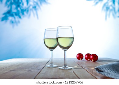 Two glasses with white wine on an old wooden table in a Christmas mood 