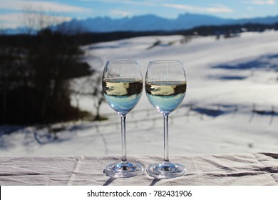 Two Glasses Of White Wine On The Balcony, Dreamlike Winter Landscape With Mountains In The Background, Happy Moment