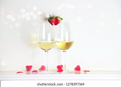 Two glasses of white wine with strawberry heart shape. Valentine's day concept 
