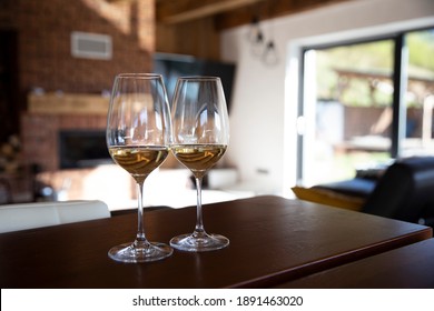 Two Glasses Of Wine In Beautiful Chalet In Front Of Fireplace. Cozy Relaxed Magical Atmosphere Staying In A Chalet Home By The Fireside. Snug Holiday Concept. Holiday In Luxury Chalet. 