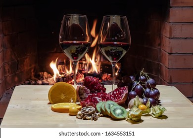 Two Glasses Of Wine, Cheese, Bread And Fruit On Fire Background