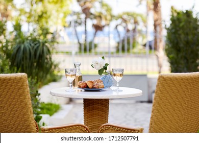 Two Glasses Of Wine And Fresh Pastries Are On The Table. Romantic Dinner For Two On The Terrace