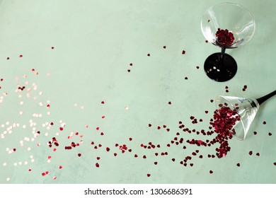 Two Glasses Of Wine With Small Heart Shaped Confetti Bursting Out Valentine's Day Concept Top View