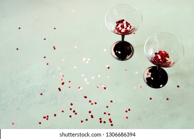 Two Glasses Of Wine With Small Heart Shaped Confetti Bursting Out Valentine's Day Concept Top View