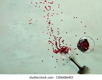 Two Glasses Of Wine With Small Heart Shaped Confetti Bursting Out Valentine's Day Concept Top View