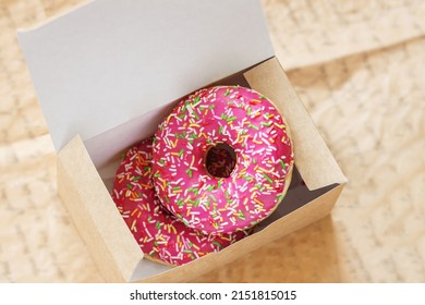 Two Glazed Pink Donuts In Paper Box Close-up. Top View. Sweets. Sale, Purchase, Delivery Of Fresh Baked Goods, Online Store