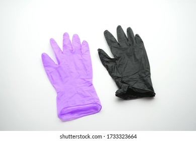 Two Gloves Of Different Colors On A White Background. Medical Gloves, Latex, Nitrile, Multicolored, Black, Lilac, On A White Background.