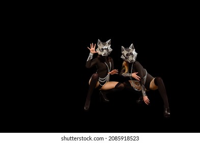 Two Go-go Variety Show Dancers In Wolf Masks On Black