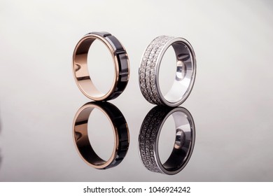 Two Gold Wedding Rings With Diamonds With Reflection On Gray Background,close - Up