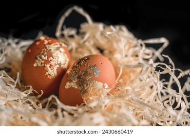 two gold-covered eggs decorated for Easter in a straw nest - Powered by Shutterstock - Get 15% off with code: PIKWIZARD15