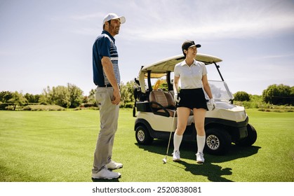 Two golfers discussing their plan while standing near a golf cart on a beautiful sunny day, holding a golf club, preparing for their round of golf. - Powered by Shutterstock