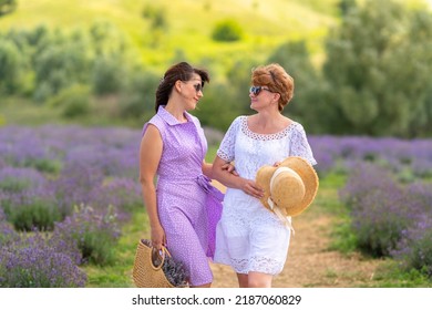 Two Good Women Friends Enjoying Quality Time Together Standing Smiling Into Each Others Eyes In A Field Of Lavender