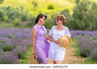 Two Good Women Friends Enjoying Quality Time Together Standing Smiling Into Each Others Eyes In A Field Of Lavender