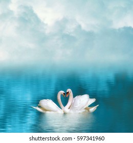 Two graceful swans in love reflecting in calm emerald water on foggy background. Swans couple on emerald lake - Shutterstock ID 597341960
