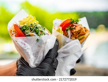 two Greek street food gyros in man hand outdoor