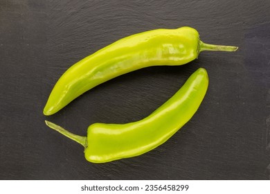 Two green chili peppers on slate stone, macro, top view. - Powered by Shutterstock