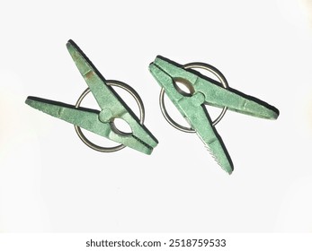 two green clothespins isolated on white background. Clothespins to prevent clothes from blowing in the wind when drying. - Powered by Shutterstock