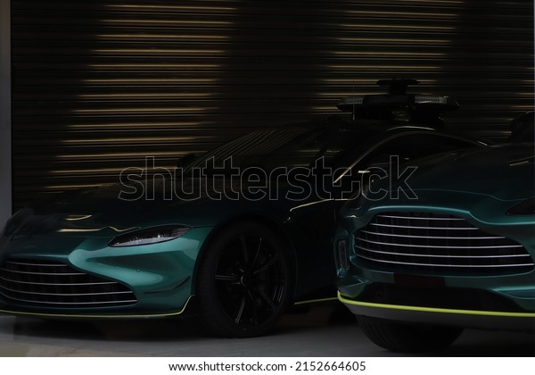 Two green luxury\
sportcars in the garage.