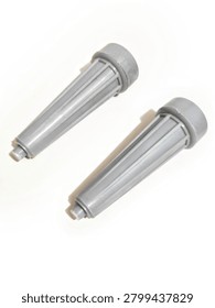 Two grey plastic pulsator rollers for washing machine, side roller agitator parts, washing machine spare parts isolated on white background with  soft shadow. Pair of white plastic side pulsator rollers for automatic washing machine. Agitator part, washing machine component, spare part for repair. Isolated on white background, macro product photography, vertical orientation.
