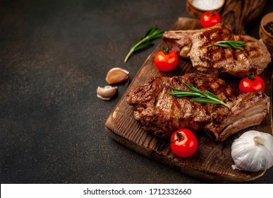 
two grilled beef steaks with spices on a stone background with copy space for your text