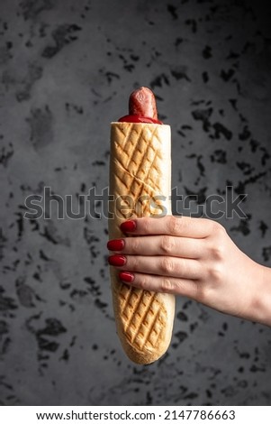 Two grilled french hot dogs in woman's hand, fast food and junk food concept, Street food,