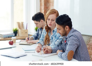 Two groupmates discussing sketch in notepad - Shutterstock ID 682639900