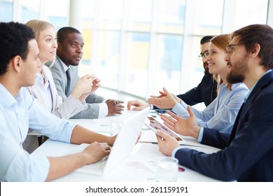 Two Groups Of People Sitting Opposite And Communicating