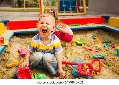 Two Grubby Kids Playing In The Sandbox