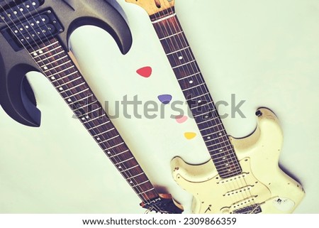 Two guitar, neck fretboard mediators plectrum on a pale.Black, white                               