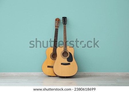 Two guitars near color wall