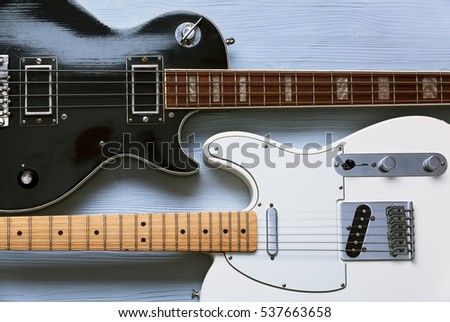 Two guitars on a light wooden board. Top view.