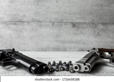 Two Guns With Bullets On The Gray Background