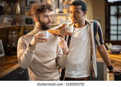 Two guys of different ethnicity having warm conversation while drinking coffee on kitchen at home. Concept of close male friendship or relationship as gay couple. Caucasian and hispanic man together - Powered by Shutterstock