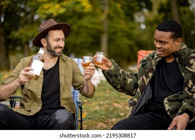 Two Guys Having Fun, Drinking Alcohol While Fishing Together On The Lake Coast. Caucasian And Latin Man Resting On Nature. Concept Of Male Friendship And Alcoholic Drinks