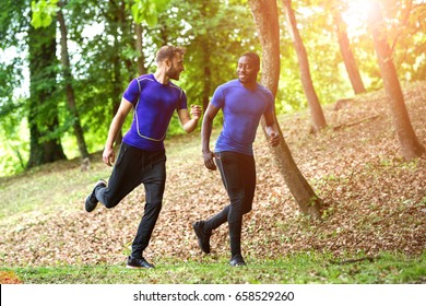 Two guys running on a forrest road - sun flare - Shutterstock ID 658529260