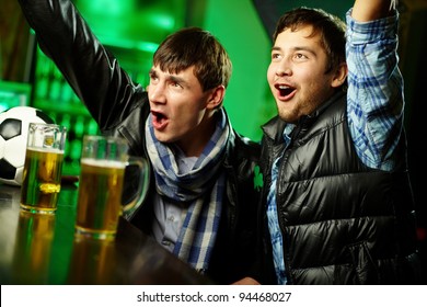 Two Guys Watching Sports At Bar And Rejoicing