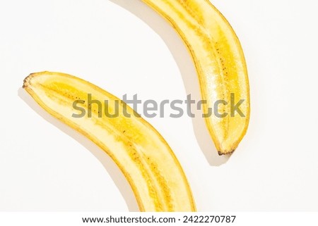 Two half of a banana on white background. Delicious and healthy fruit