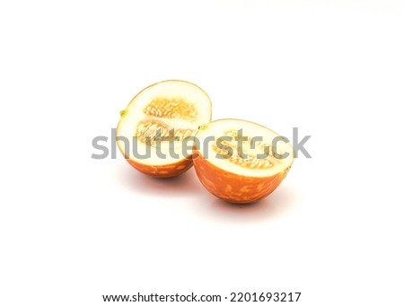 Two half cut of Tigger melon (Armenian cantaloupe) with cream-colored oval seeds suspended in a mixture of gelatinous liquid isolated on white background. Vibrant yellow with zigzag stripes