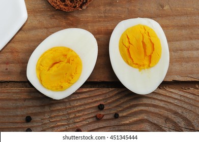 Two Halves Of Boiled Eggs On Wooden Rustic Background. The View From The Top