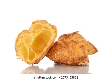 Two halves of a fragrant Chouquette on in a glass dish, close-up, isolated on white.