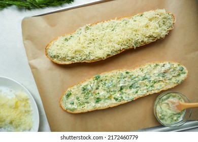 Two Halves Of A Garlic-cream Baguette On A Proven. The Process Of Cooking Garlic Baguette With Cheese And Herbs.  Baguette With Garlic.