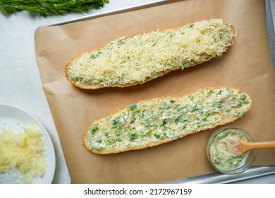 Two Halves Of A Garlic-cream Baguette On A Proven. The Process Of Cooking Garlic Baguette With Cheese And Herbs.  Baguette With Garlic.