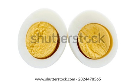 Two halves of a hard boiled egg showing yellow yolk and white albumen