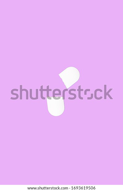 Two halves of a medical pill broken by a\
dividing notch. Medical pill isolated on a pink background. Flat\
lay. Copy space. Medical pill\
concept.